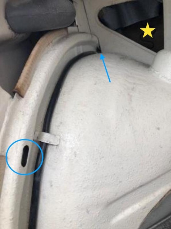 Figure 7 Oval wheelhouse box metal hole and triangular cutout in a 1967 BMW1600BMW1600-2. Circle at “vent and drain” box metal oval hole. Arrow points to wire chase penetrating the bulkhead. Star in triangular cutouts that allow for primer distribution and air bubble release during electrophoresis primer immersion. Photo: Robert P. Smith