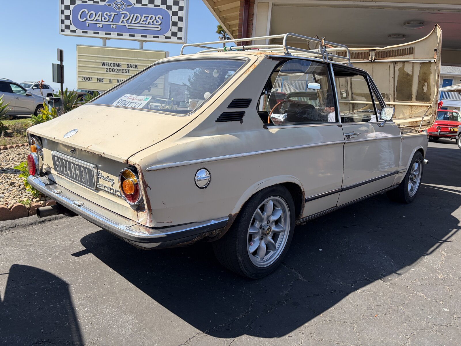 A BMW Touring beside the welcome sign at Coast Riders Inn