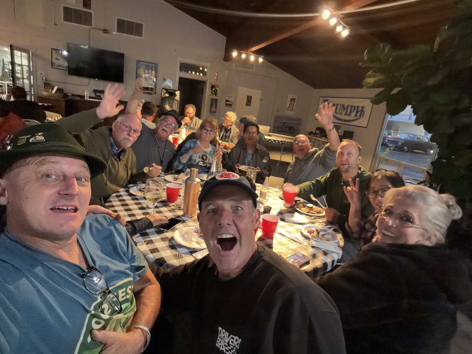 A table of enthusiasts waving and laughing together
