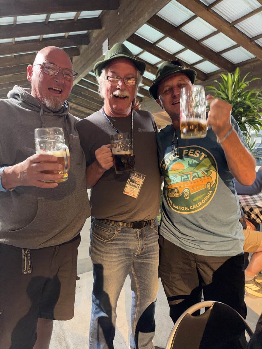 Three friends raising their glasses in a mini-Oktoberfest toast