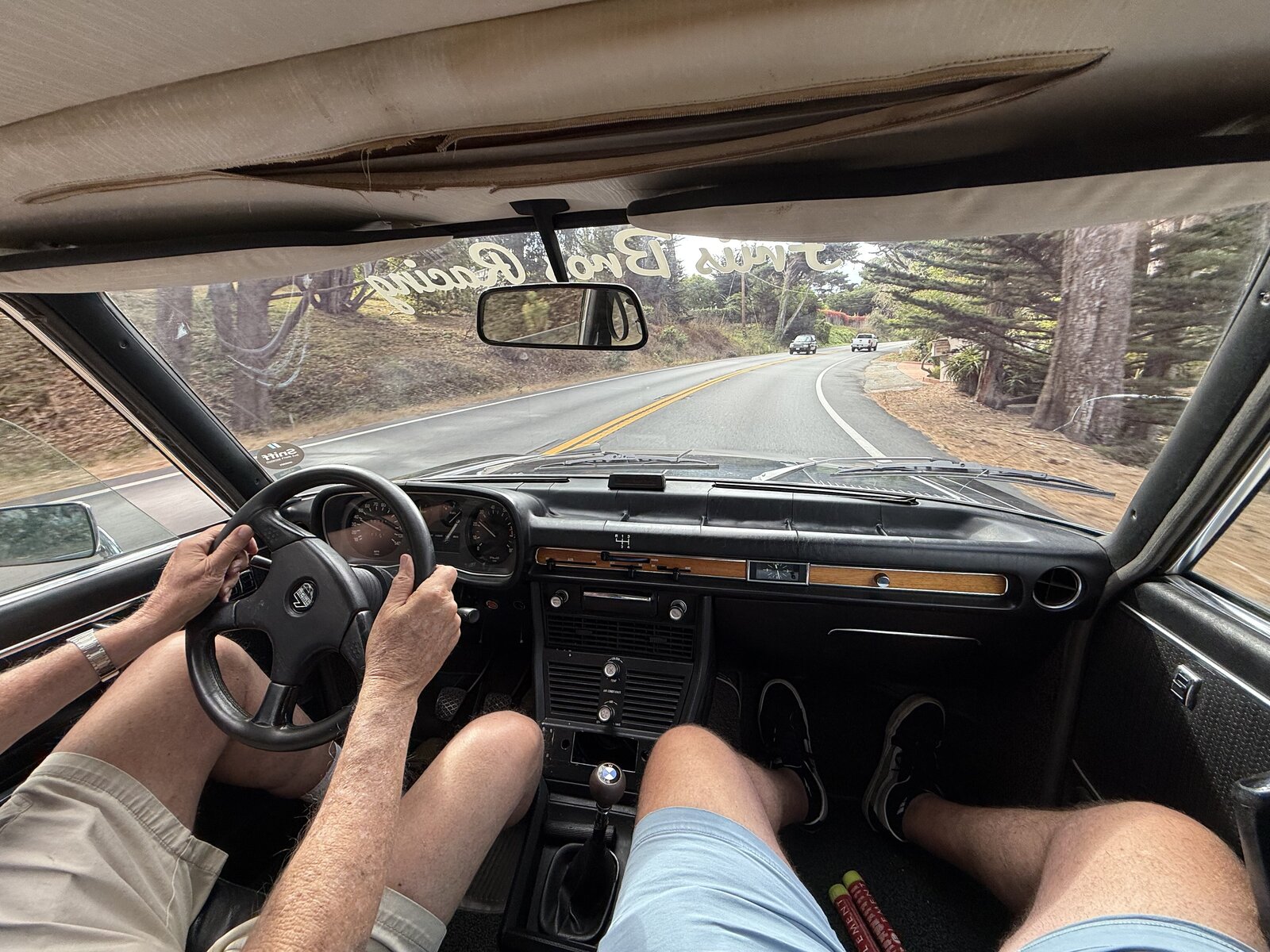 A view from inside a BMW as the road winds through the trees