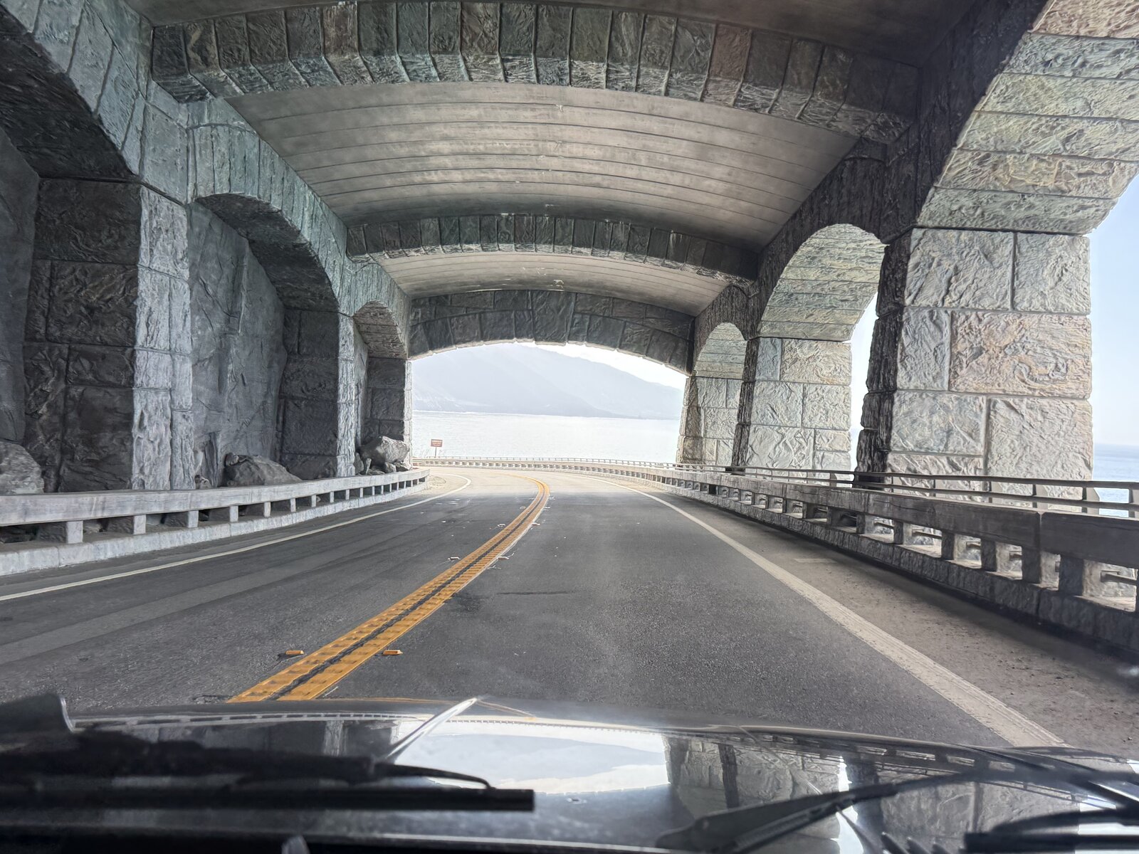 The coastal road viewed through a stone-sided road shelter